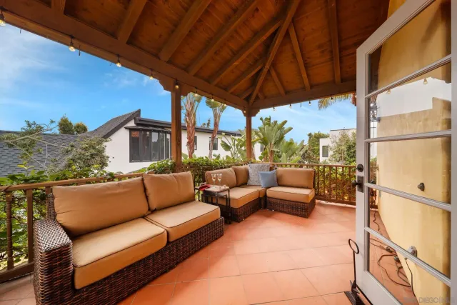 a living room with stainless steel appliances furniture a rug and a kitchen view