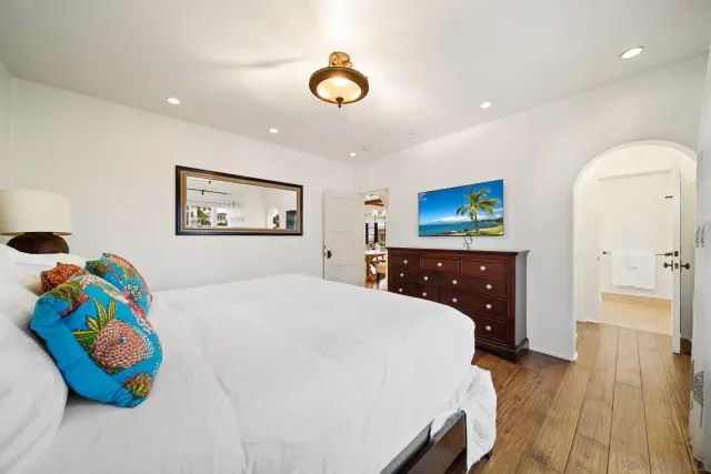 a spacious bedroom with a bed and a dresser