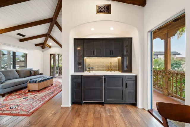 a large bed sitting in a spacious bedroom next to a dining table & chairs with wooden floor