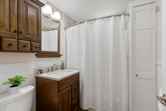 a bathroom with a sink a mirror and a shower curtain