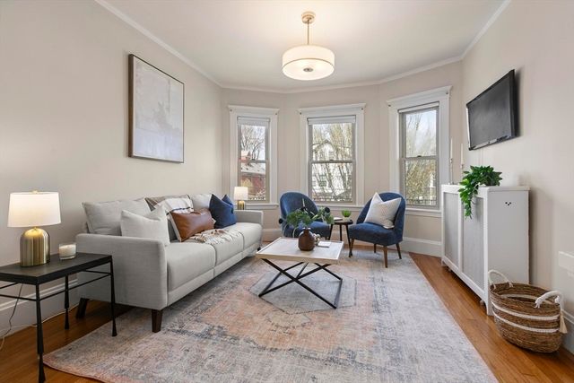 a living room with furniture a flat screen tv and a window