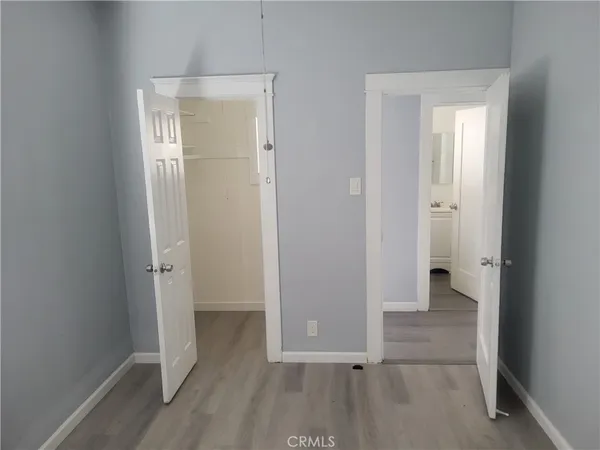 an empty room with wooden floor and a sink