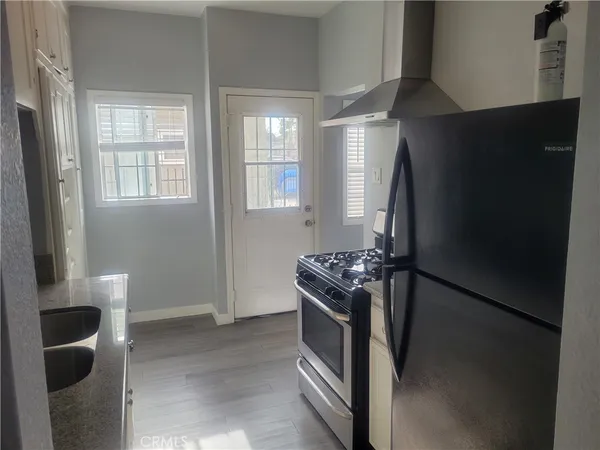 a kitchen with stainless steel appliances granite countertop a refrigerator and a stove