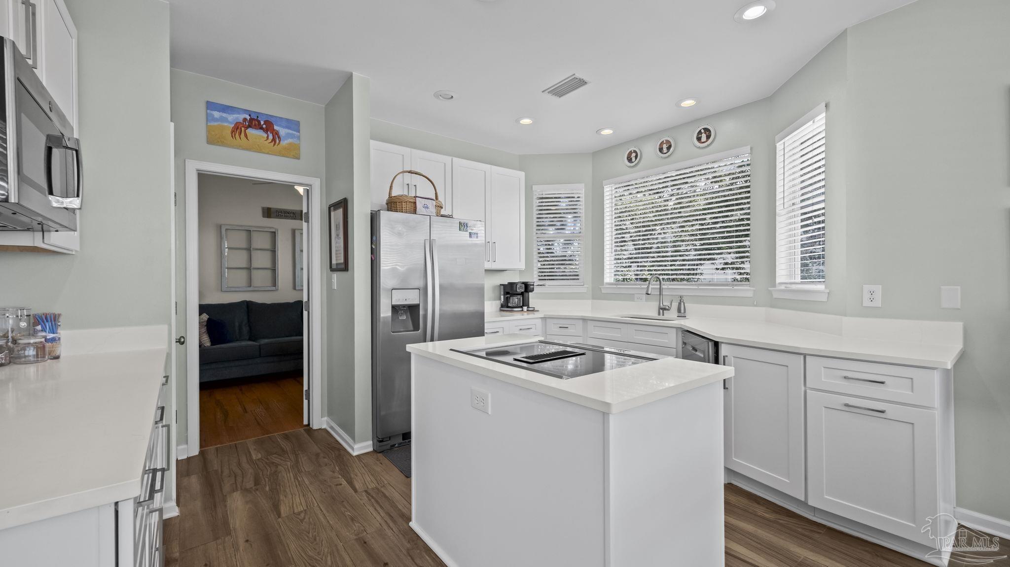 32580 Sandpiper Drive Orange Beach, AL 36561 - Photo 12 of 52 a kitchen that has a lot of cabinets in it and wooden floors