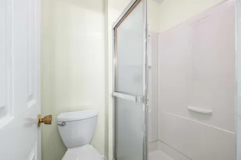 a white toilet sitting next to a shower