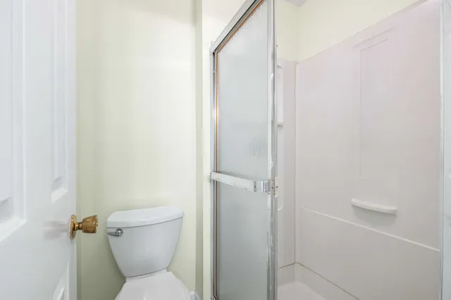 a white toilet sitting next to a shower