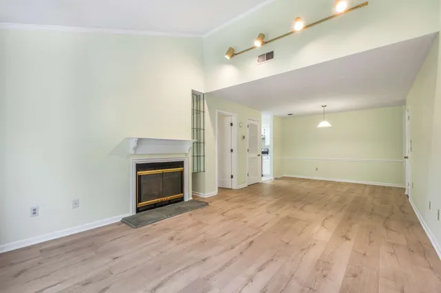 a view of empty room with wooden floor and fireplace