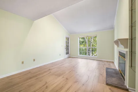 a view of a room with wooden floor and a fireplace