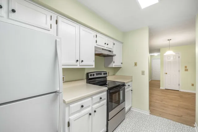 a kitchen with stainless steel appliances a stove a refrigerator and cabinets