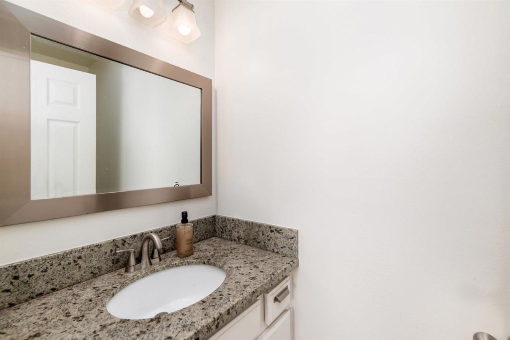 4239 Vista Del Rio Way, Unit 6 Oceanside, CA 92057 - Photo 16 of 30 a bathroom with a granite countertop sink and a mirror
