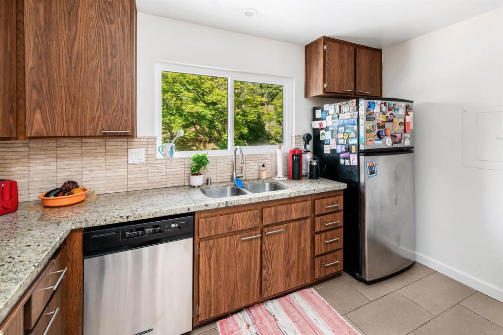 4239 Vista Del Rio Way, Unit 6 Oceanside, CA 92057 - Photo 7 of 30 a kitchen with stainless steel appliances granite countertop a sink stove and refrigerator