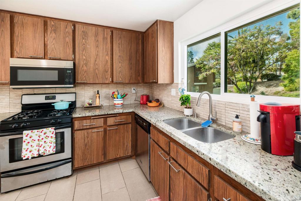 4239 Vista Del Rio Way, Unit 6 Oceanside, CA 92057 - Photo 8 of 30 a kitchen with stainless steel appliances granite countertop a sink stove and cabinets