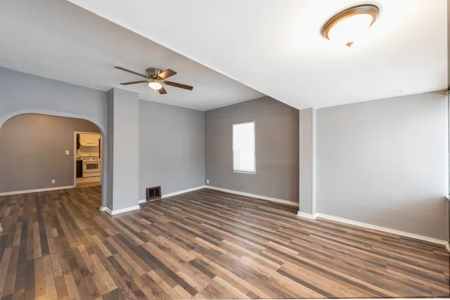a view of empty room with wooden floor