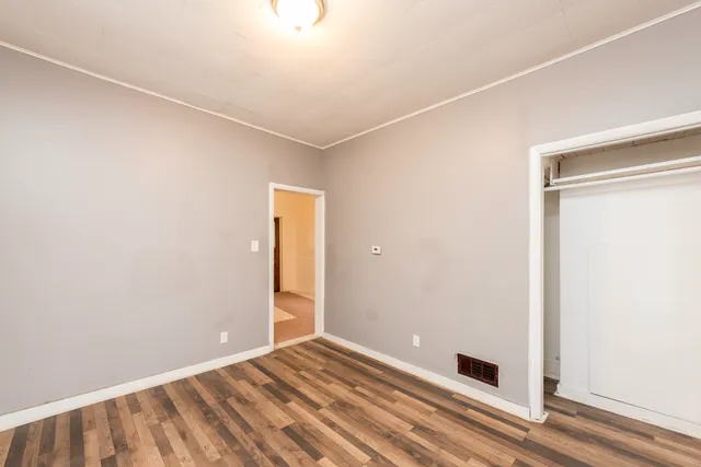 a view of a room with wooden floor and white walls