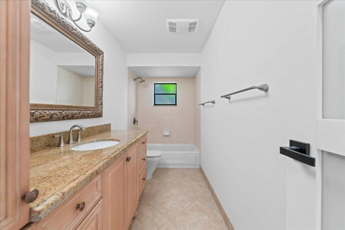 8600 Gatehouse Road Plantation, FL 33324 - Photo 24 of 27 a bathroom with a granite countertop sink a mirror and a bathtub