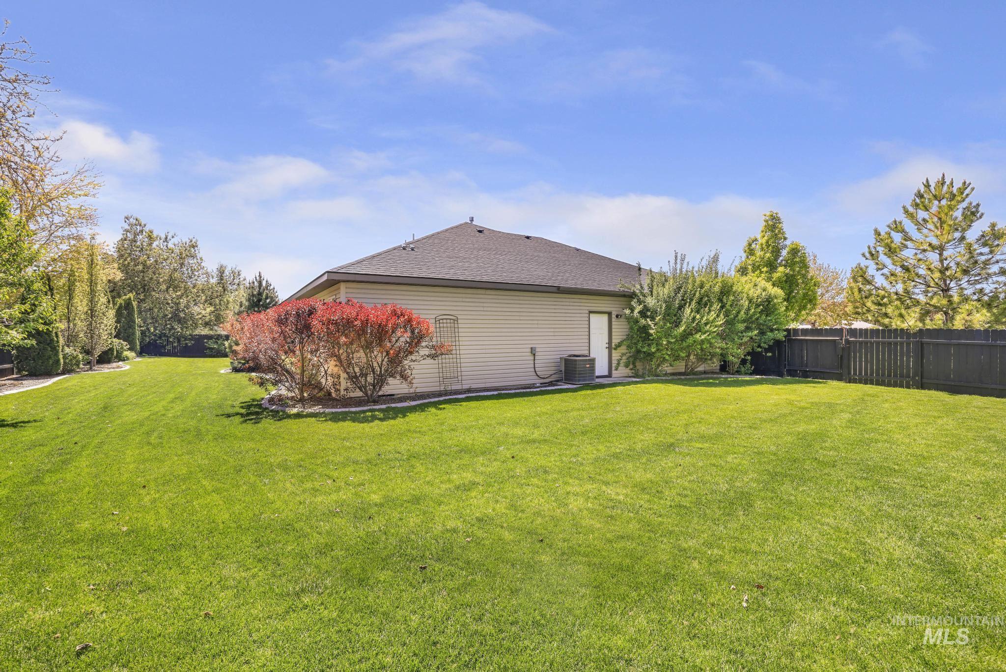 1937 Tamarack Loop Twin Falls, ID 83301 - Photo 44 of 50 Spacious backyard featuring a lush lawn, mature trees, and privacy fencing