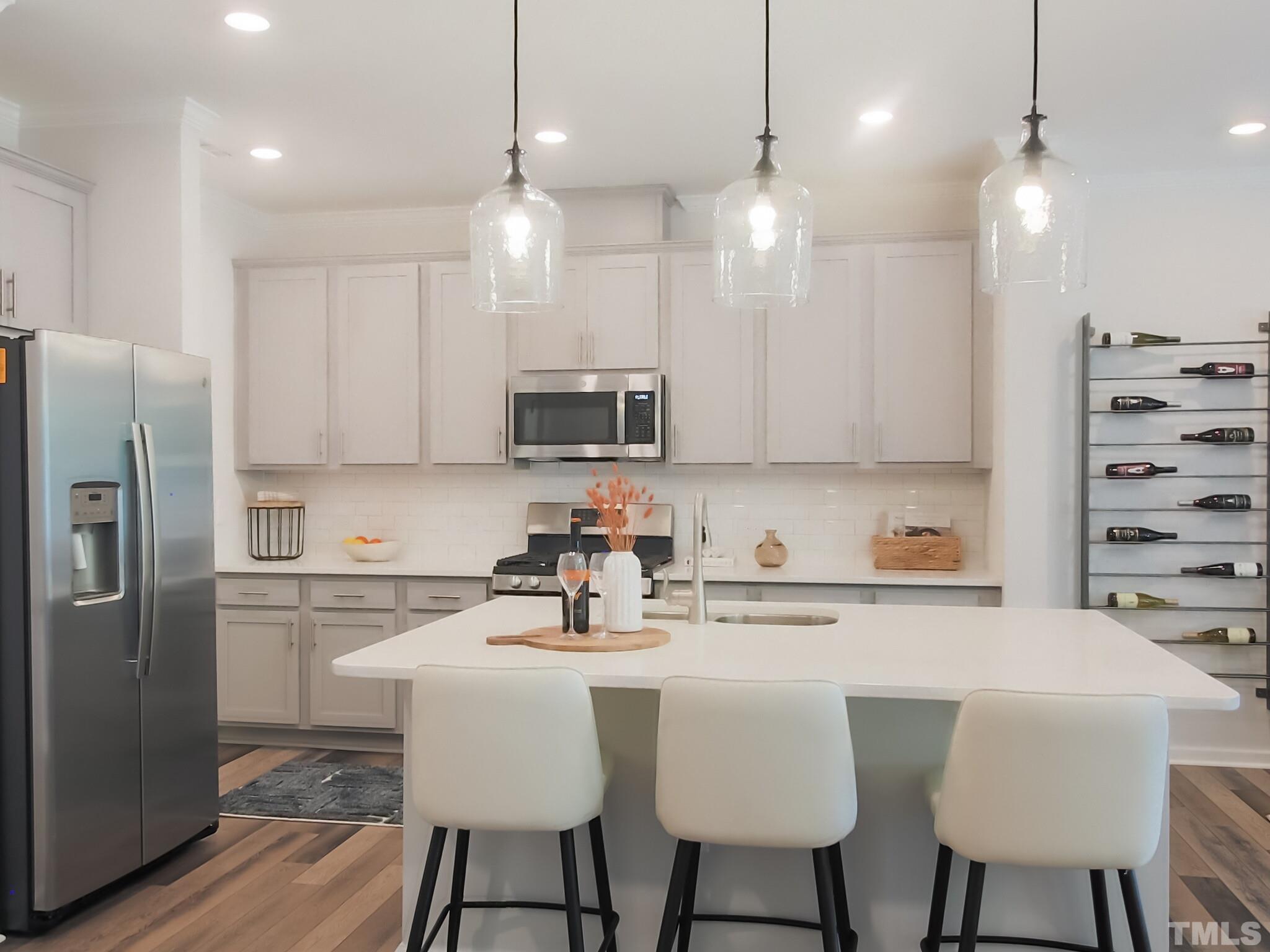 1622 Emory Ridge Way, Unit 22 Wake Forest, NC 27587 - Photo 8 of 24 a kitchen with stainless steel appliances a dining table chairs refrigerator and microwave
