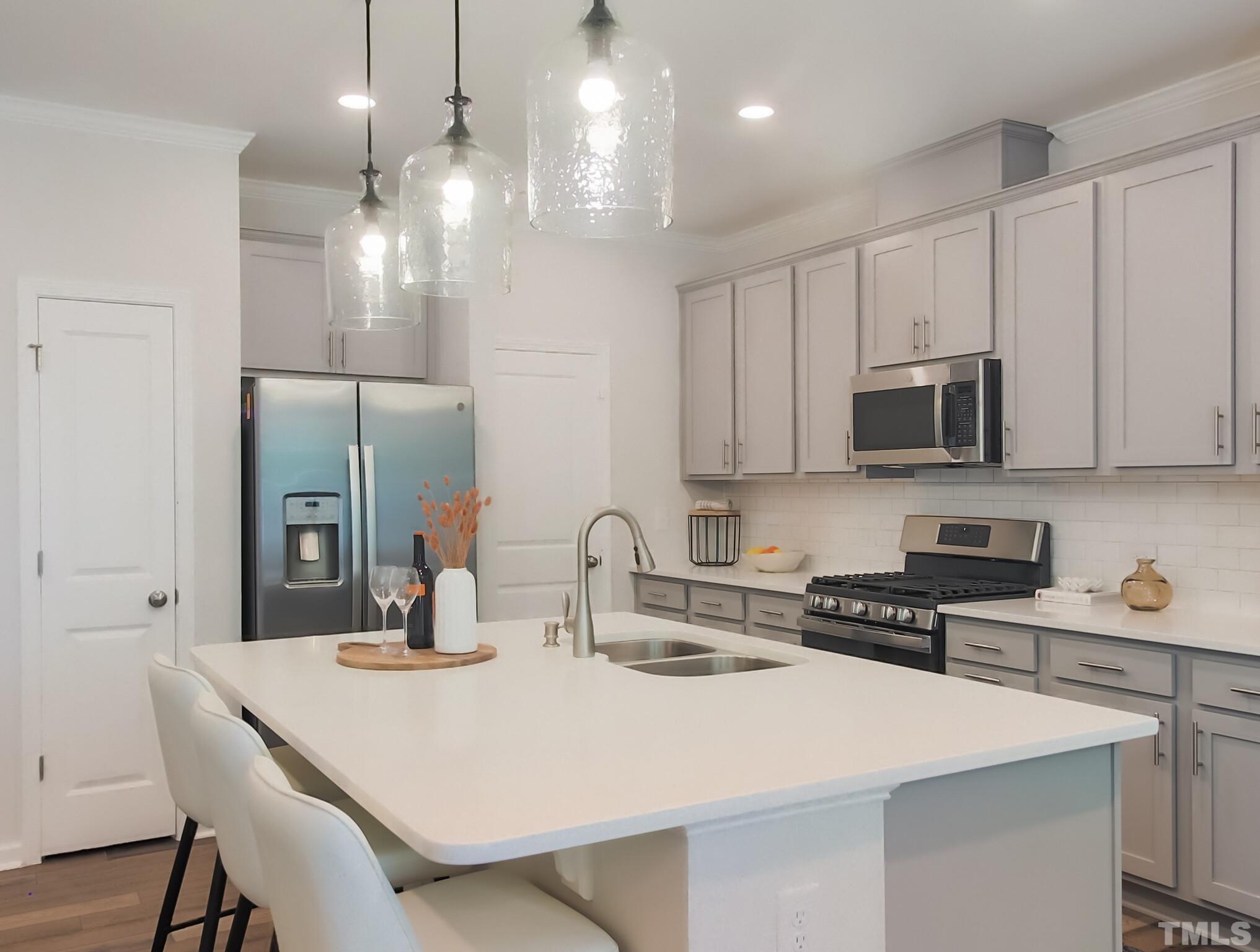 1622 Emory Ridge Way, Unit 22 Wake Forest, NC 27587 - Photo 9 of 24 a kitchen with stainless steel appliances a sink a stove a refrigerator and cabinets