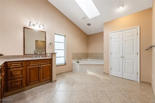 a spacious bathroom with a granite countertop sink mirror and a bathtub