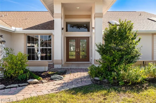 a front view of a house with a yard and potted plants