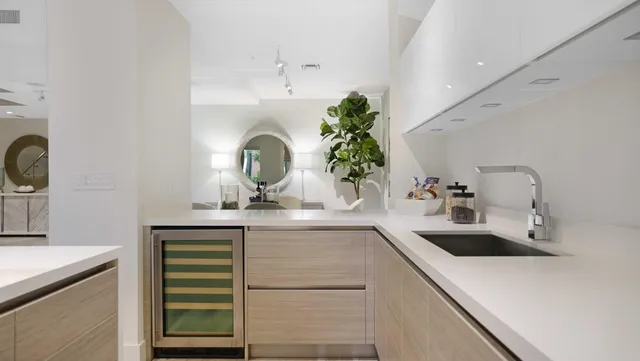 a room with stainless steel appliances kitchen island a table and chairs in it