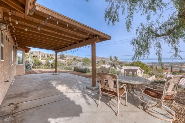 a view of a patio with table and chairs with wooden floor and fence