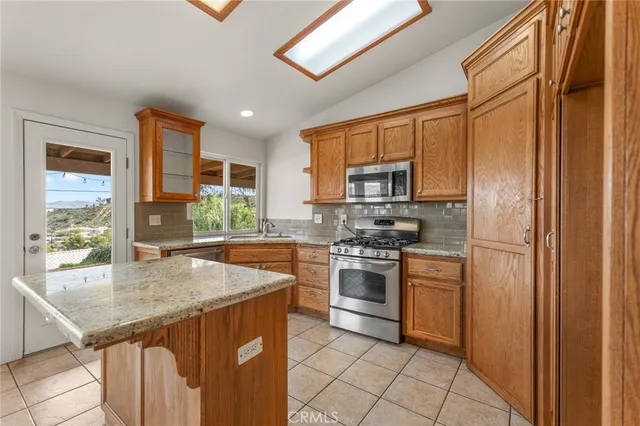 a kitchen with stainless steel appliances granite countertop a stove a refrigerator and a sink