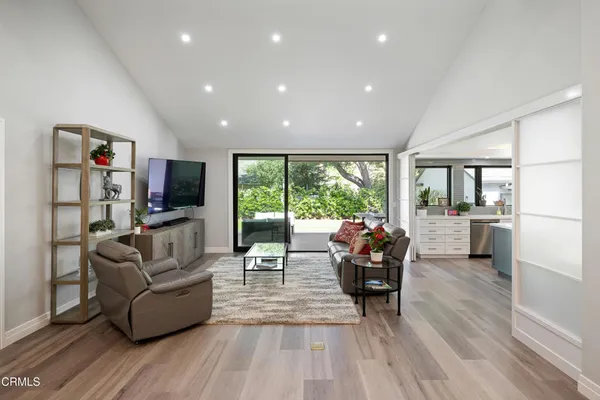 a kitchen that has a lot of white cabinets and stainless steel appliances