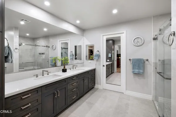 a bathroom with double vanity sink toilet and shower