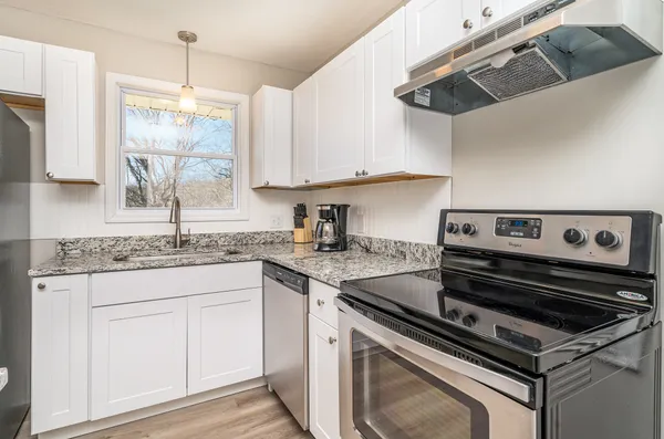 a kitchen with stainless steel appliances granite countertop a sink stove and cabinets