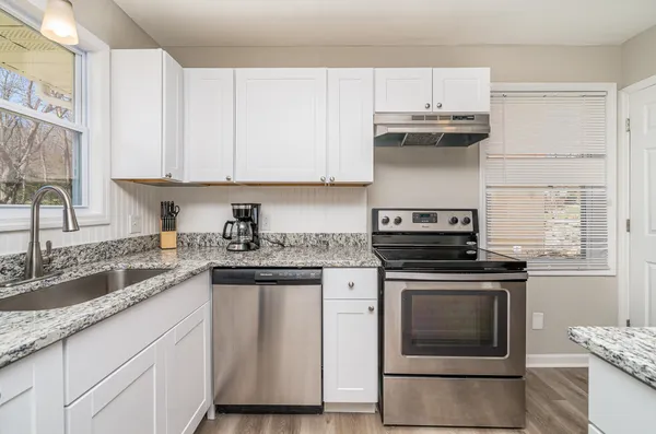 a kitchen with stainless steel appliances granite countertop a stove a sink and a microwave