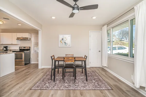 a dining room with wooden floor and a window