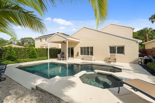 a view of a house with swimming pool and sitting area