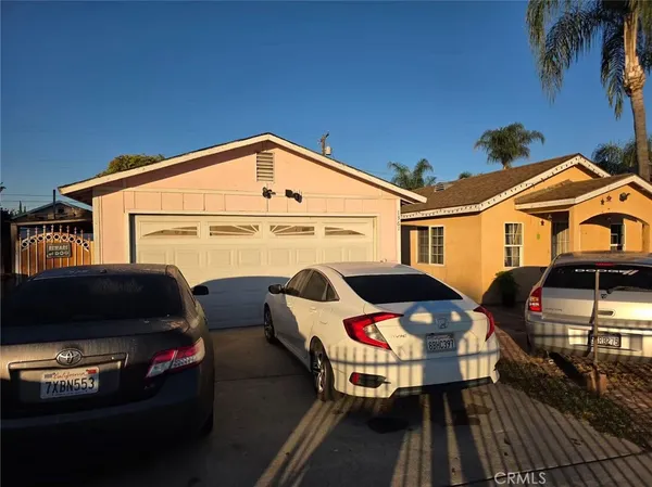 a front view of a house with cars parked