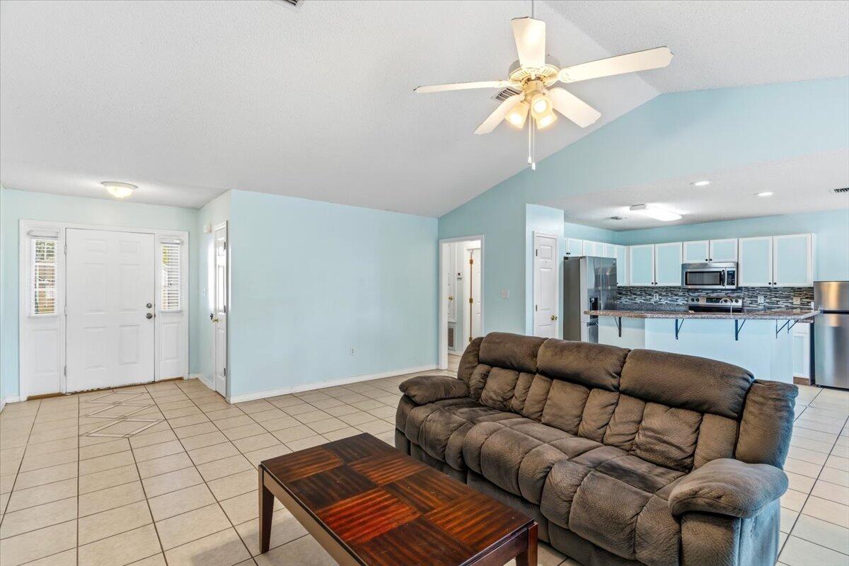 7095 Jasper Street Navarre, FL 32566 - Photo 11 of 26 a living room with furniture and a chandelier