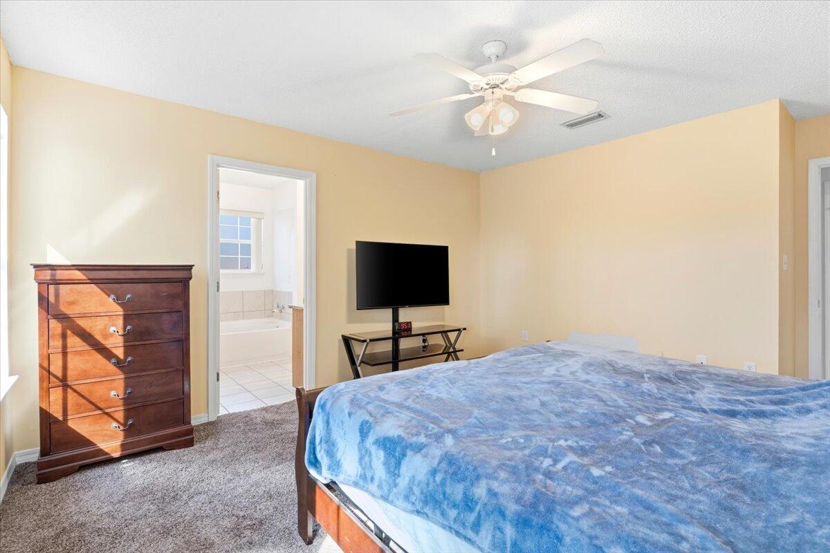 7095 Jasper Street Navarre, FL 32566 - Photo 16 of 26 a bedroom with a bed and a television