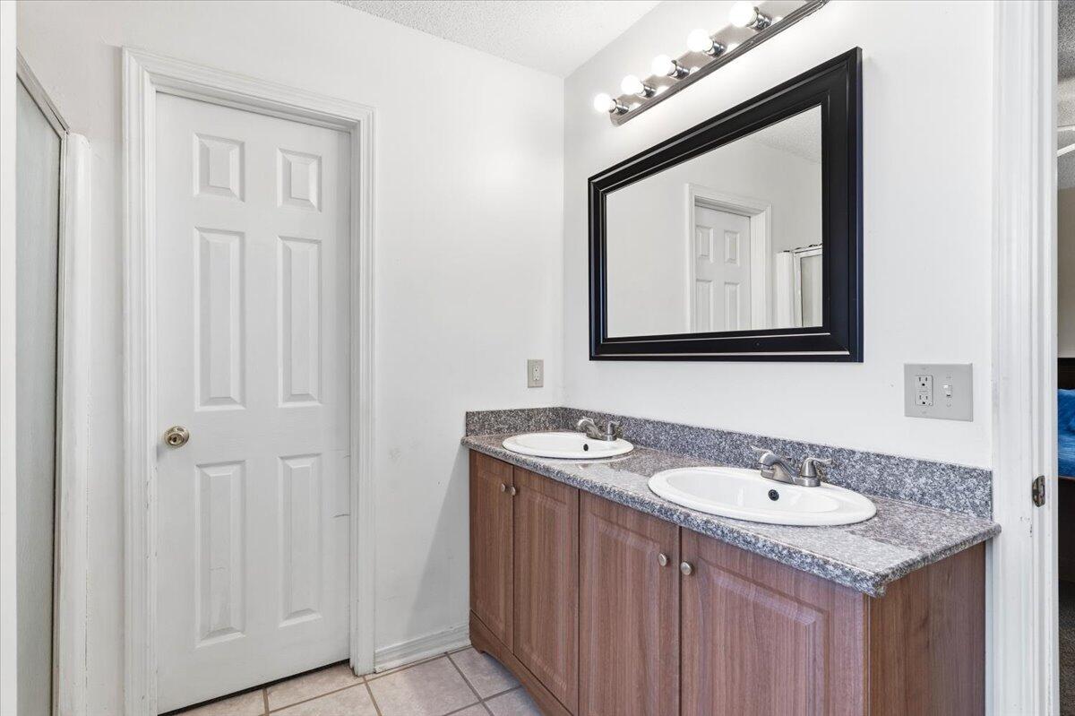 7095 Jasper Street Navarre, FL 32566 - Photo 19 of 26 a bathroom with a sink vanity and a mirror