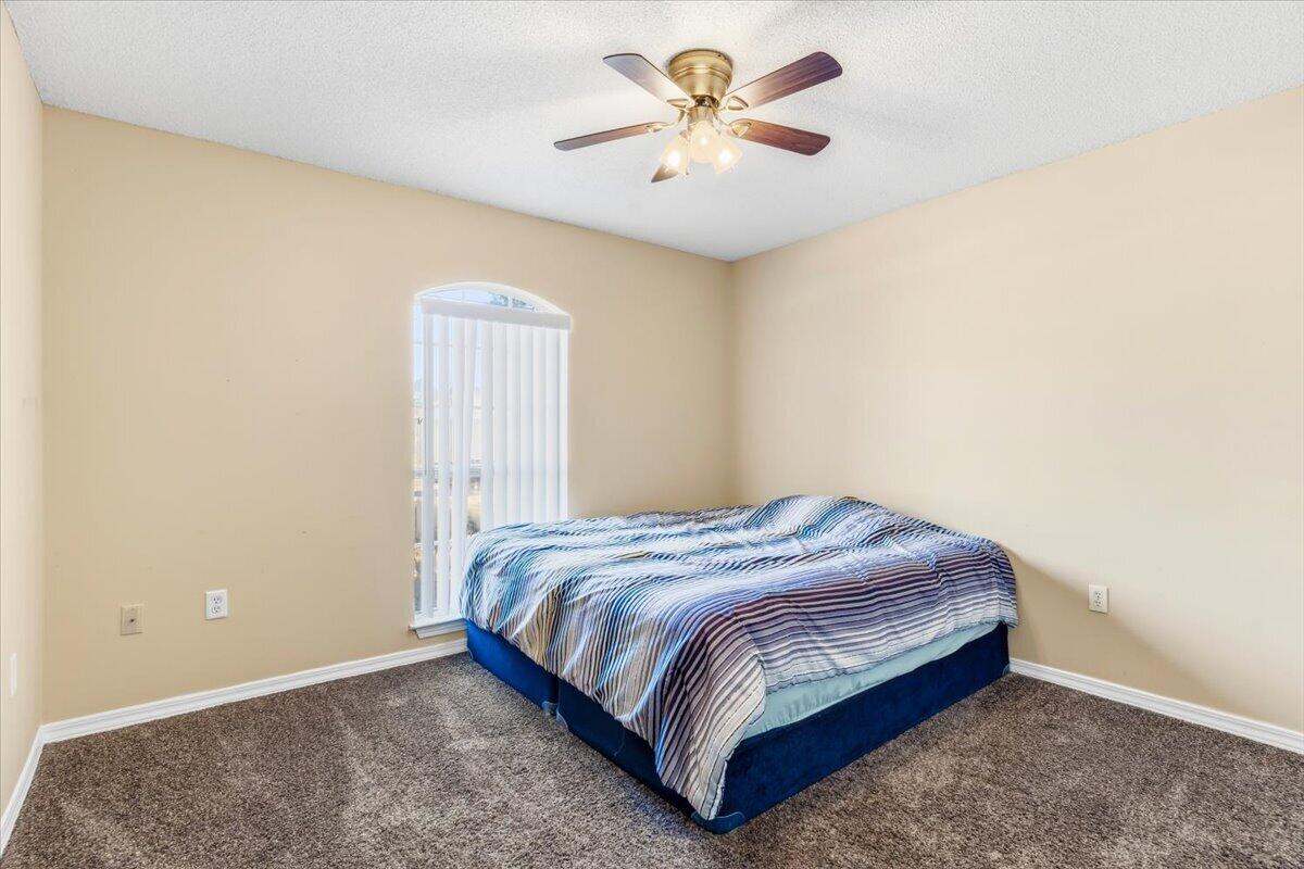 7095 Jasper Street Navarre, FL 32566 - Photo 21 of 26 a bedroom with a bed and a chandelier