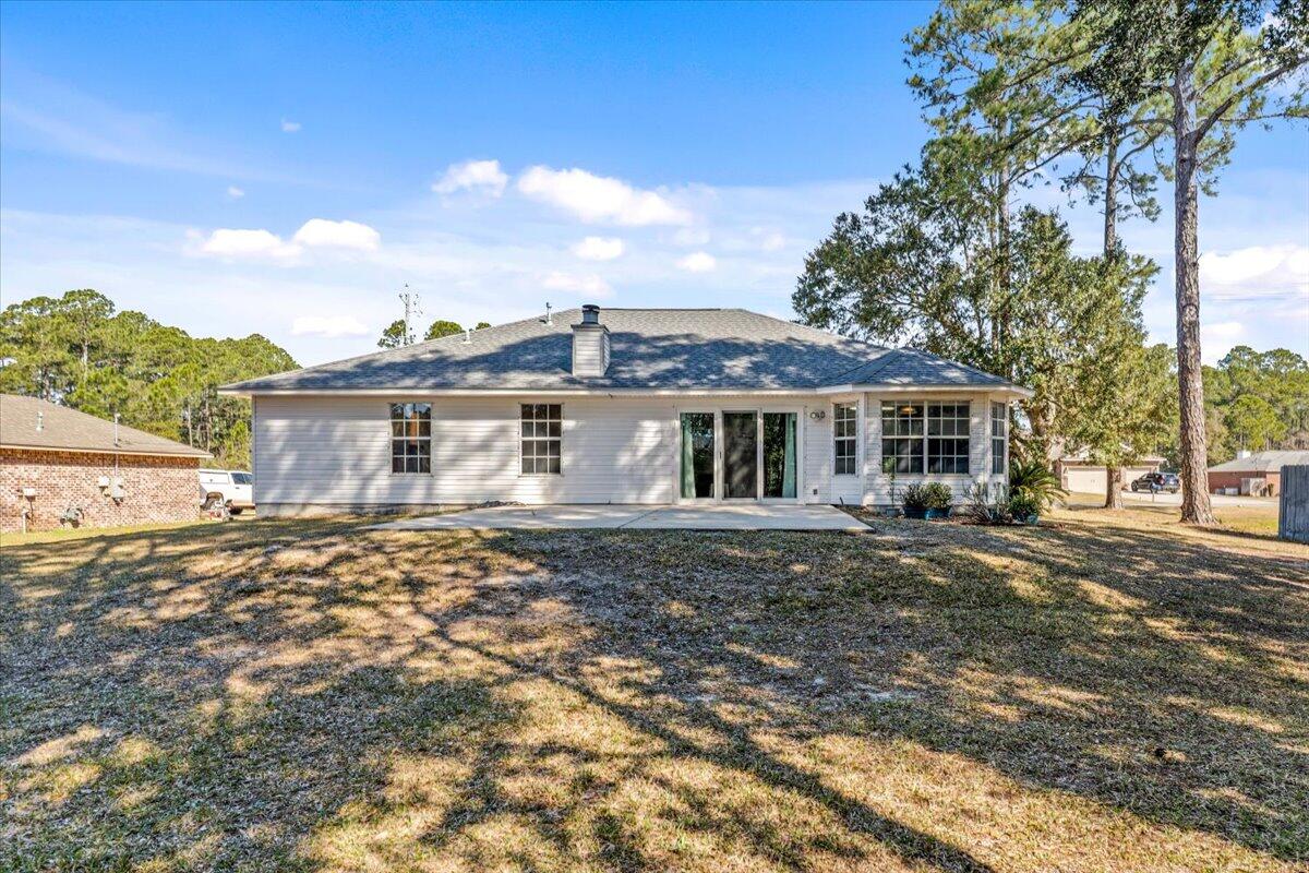 7095 Jasper Street Navarre, FL 32566 - Photo 9 of 26 a front view of a house with a garden