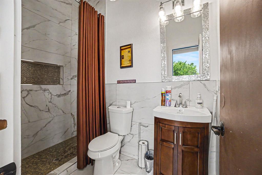 505 South Bluegrove Road Lancaster, TX 75146 - Photo 24 of 37 a bathroom with a sink toilet and shower
