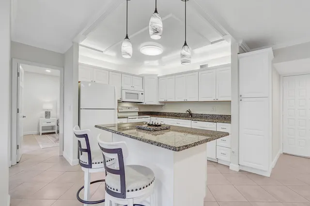 a room with white cabinets and chandelier