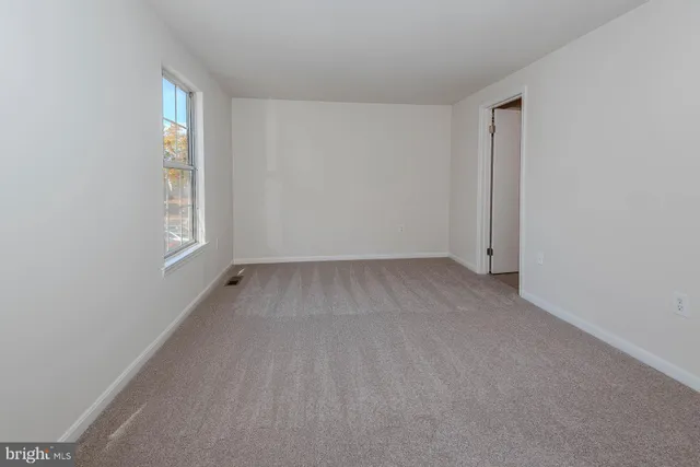 an empty room with windows and closet
