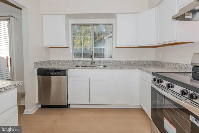 a kitchen with a sink stove and cabinets