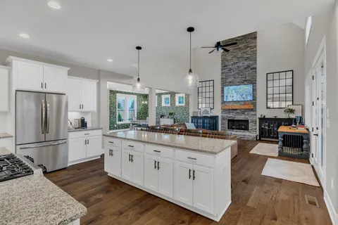 a kitchen with stainless steel appliances a dining table chairs refrigerator sink and microwave