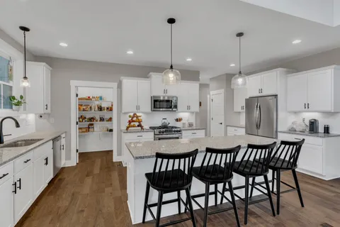 a kitchen with stainless steel appliances granite countertop a stove a sink and a granite counter tops