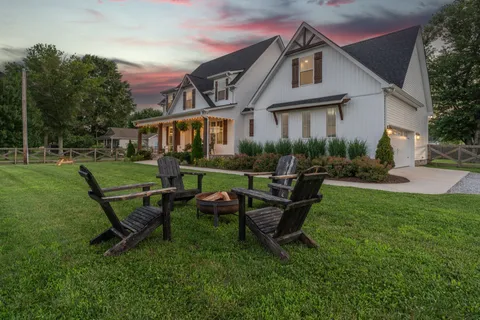 a view of a house with a yard and sitting area