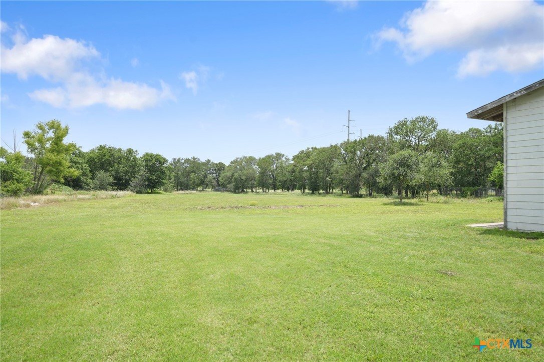 9725 Bock Road Buda, TX 78610 - Photo 35 of 37 A verdant, open field provides ample space for outdoor activities and future expansion.
