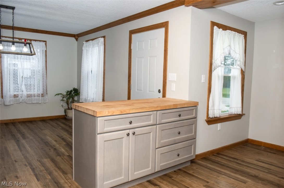 1721 State Road Northwest Warren, OH 44481 - Photo 6 of 37 Kitchen with pendant lighting, dark wood-type flooring, an inviting chandelier, wooden counters, and a textured ceiling
