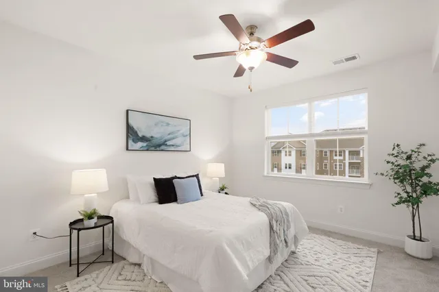 a bedroom with a large bed and a potted plant