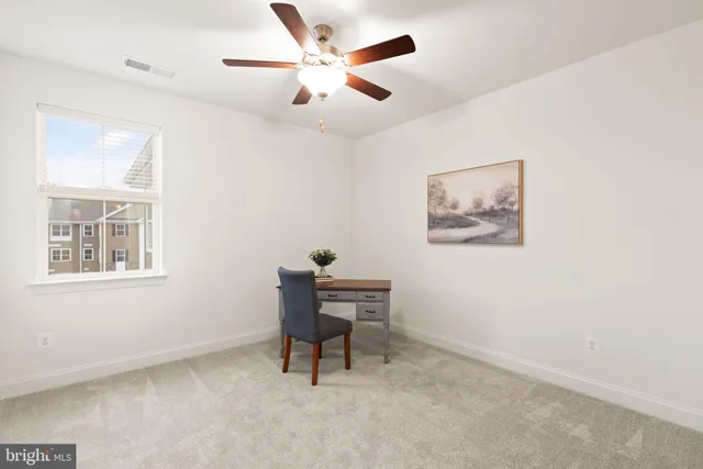 a view of a workspace with furniture and a window